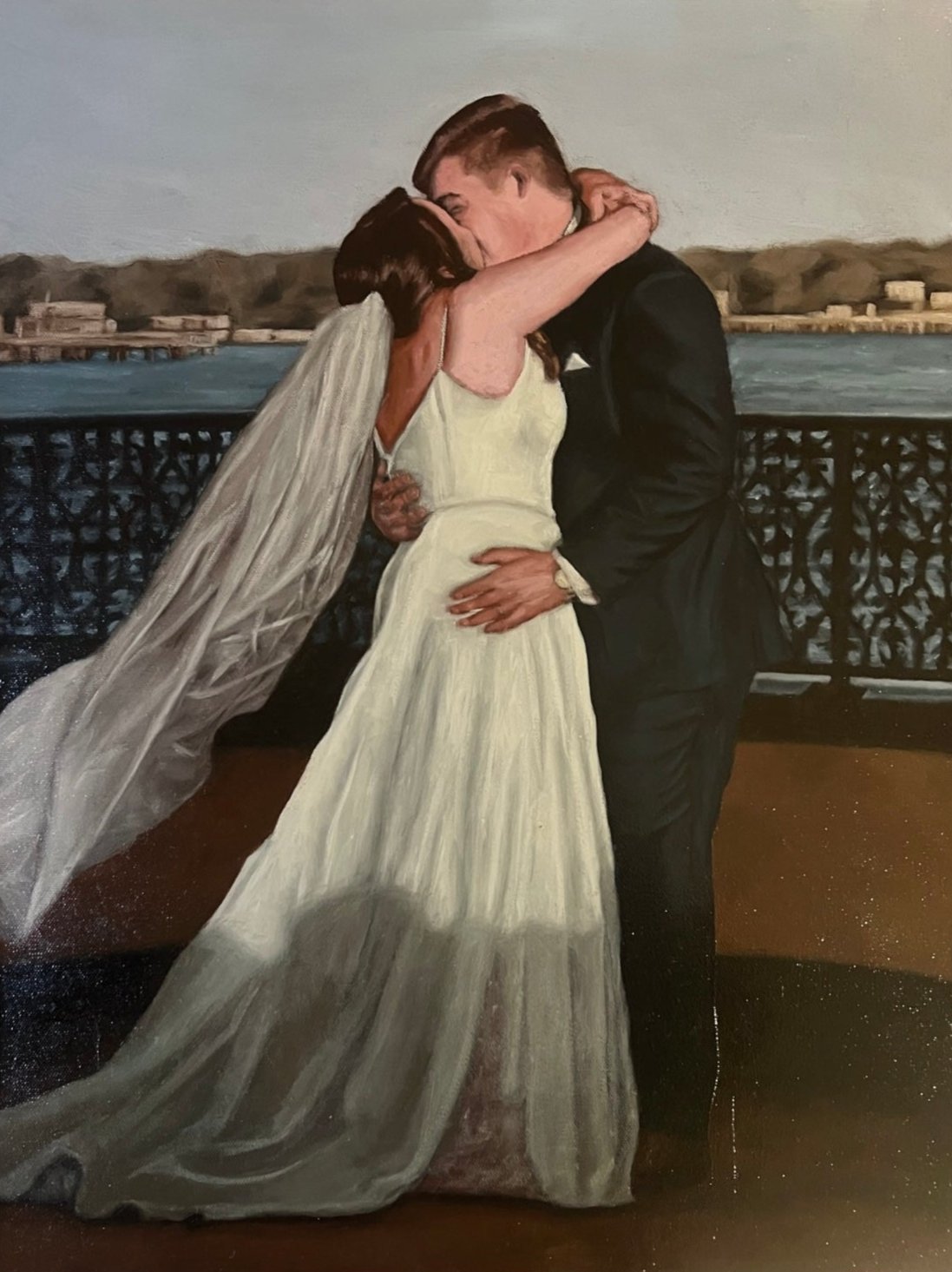 Bride and groom kissing in front of river.